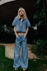 Camisa de denim de corte recto y manga corta, con cuello solapa, cierre frontal con cremallera y dos bolsillos delanteros de plastrón.