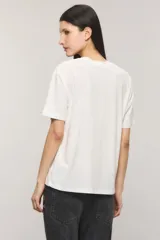 Remera oversize de jersey de algodón color blanco, con cuello redondo, mangas cortas y estampa frontal en blanco y negro de estilo collage fotográfico.