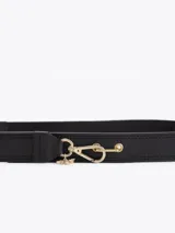 Cinturón negro confeccionado en cuero vacuno con un segmento elastizado, cierre de mosquetón metálico dorado y detalle de dije con diseño de abeja.