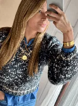 Collar con dije grande en forma de sol con rostro central, realizado en bronce y suspendido mediante un tiento de cuero marrón.