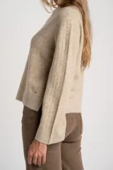 Sweater de punto con textura acanalada vertical, color beige melange, de cuello redondo y manga larga con puños rectos.