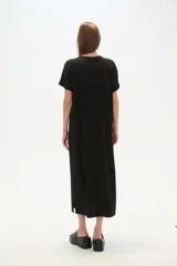 Vestido midi de corte holgado, color negro, con mangas cortas, cuello en V y detalle de cuentas decorativas en el escote.