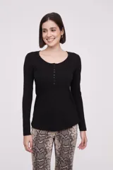 Remera blanca de manga larga, entallada, con cuello redondo y una hilera de botones en el frente. Incluye un pequeño bolsillo decorativo en el pecho.