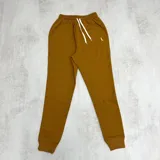 Pantalón de jogging color terracota con puños ajustados, cordón ajustable en la cintura y logo bordado en el muslo.