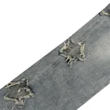 Pantalón de jean celeste con roturas en forma de estrella y corte recto.