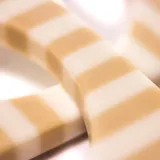 Conjunto de tres pulseras cuadradas de resina, rayadas en blanco y beige.