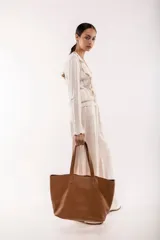 Bolso tote de cuero color tostado, con doble asa de hombro y diseño minimalista. Incluye un bolsillo separador extraíble.