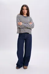 Pantalon de jean ancho azul oscuro con alforzas frontales y diseño de tiro alto.