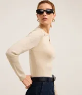 Blusa de punto ajustada color negro, con cuello polo y escote pronunciado en V. Presenta un tejido acanalado vertical en el torso y mangas largas.