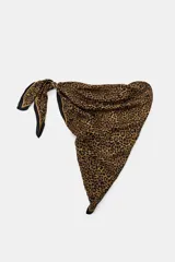 Pañuelo tipo pareo con estampado animal print, confeccionado en viscosa. Presenta un diseño triangular con cierre mediante arandelas metálicas y mosquetón.