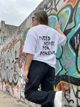 Remera blanca de corte oversize con estampa en la espalda con la frase "Need Money For Porsche" en color negro.
