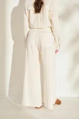 Pantalón ancho negro de lino con cintura elástica y detalles de flecos en los laterales.