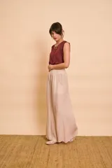 Blusa de satén color bordó, sin mangas, con cuello redondo y detalles de ribete bordado en contraste en las sisas.