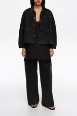 Chaqueta corta de corte línea A confeccionada en mezcla de algodón color negro. Presenta cuello camisero, mangas largas con botones, bolsillos delanteros tipo plastrón y canesú con maxi pliegue en la espalda.