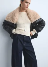 Pantalón de jean estilo wideleg de tiro medio, con pinzas delanteras, cierre de botón y cremallera, y cuatro bolsillos.