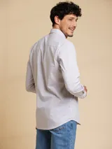 Camisa de manga larga con diseño de rayas finas verticales, cuello abotonado y cierre frontal con botones.