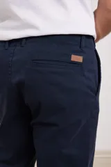 Pantalón chino de hombre color verde oscuro, corte slim, confeccionado en algodón con elastano, con triple pespunte en las costuras y botones al tono.