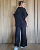 Pantalón de punto calado color crudo, de corte palazzo y cintura elástica.