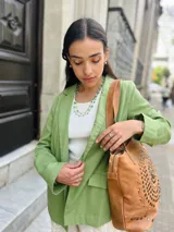 Blazer sastrero color verde, de lino, con solapas de muesca y mangas largas que se pueden remangar.