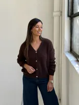 Saco tipo cardigan de punto color chocolate, con escote en V, cierre frontal de botones y mangas largas con puños acanalados.