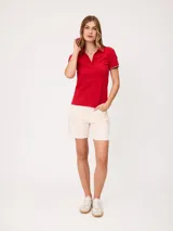 Remera polo azul marino de manga corta, con cuello en V sin botones y ribetes tricolores en el cuello y los puños.
