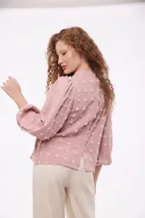 Blusa color beige con cuello mao, mangas 3/4 abullonadas y textura de lunares en relieve.