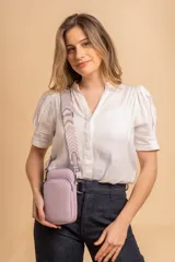 Bandolera compacta color rojo con textura de cuero, correa regulable y desmontable con diseño de rayas rojas y blancas. Cuenta con bolsillos frontales y cierre, interior forrado en tela.