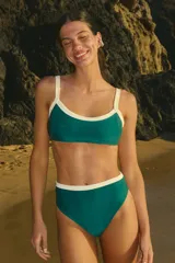 Bikini de lycra mate color verde esmeralda con detalles en color crema. El top es de corte cuadrado con breteles regulables y ribetes anchos a contratono. La bombacha es de tiro alto con cintura a contratono.