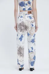 Pantalón de tiro alto y piernas amplias, confeccionado en gabardina de algodón estampada con diseño floral en tonos azul, beige y marrón.