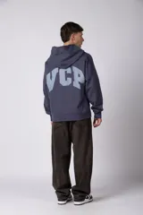 Buzo canguro negro con capucha, confeccionado en algodón frizado de alto gramaje. Presenta estampado gráfico en el pecho con tipografía cursiva y texto, además de un logo circular en la manga. Cuenta con bolsillo frontal tipo canguro, puños y ruedo acanalados.