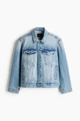 Campera trucker de denim de algodón rígido en color celeste con lavado claro, cuello camisero, cierre frontal de botones metálicos, bolsillos con solapa en el pecho y bolsillos laterales.