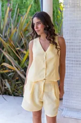 Conjunto de chaleco con botones y bermuda de crepé color rojo. El chaleco es sin mangas y con escote en V. La bermuda es de tiro alto y corte holgado.