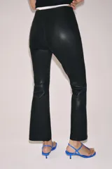 Pantalón de tiro medio confeccionado en piel 100%, con diseño de corte flare o evasé en el bajo y cierre de cremallera oculta en la costura lateral.
