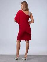 Vestido corto negro de RM Richards, con un hombro descubierto y una manga corta con volado. Presenta un aplique de lentejuelas plateadas en el tirante.