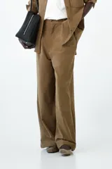 Pantalón de pana de corte recto y amplio, color tostado. Presenta pasacintos, cierre frontal con botón y bolsillos funcionales.