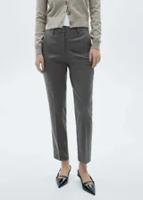 Pantalón gris de tiro medio, corte skinny y diseño crop con trabillas para cinturón y bolsillos laterales.
