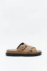 Sandalia marrón con tiras cruzadas y hebilla metálica lateral.