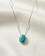 Collar de cadena fina de plata 925 con dije ovalado engarzado que contiene una piedra natural color turquesa.