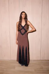 Vestido largo negro con estampado de lunares blancos, confeccionado en jersey con lurex y encaje. Presenta escote en V profundo, tirantes finos y detalles de encaje en el pecho y el ruedo.