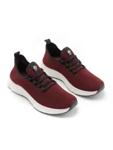 Championes deportivos de tejido mesh color beige, con cordones negros y suela blanca texturizada. Presenta detalles en negro en el borde del cuello y una tira decorativa en el talón.