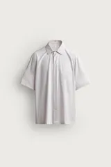 Camisa azul marino de corte regular fit confeccionada en tejido fluido de algodón y lino, con cuello solapa, manga corta, bolsillo aplicado en el pecho y cierre frontal con botones.