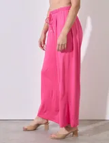 Pantalón de seda fría color fucsia, de pierna ancha, con pretina ancha elastizada en punto smock y cordón de ajuste.