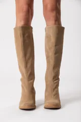 Bota bucanera de caña alta color visón, confeccionada en cuero descarne, con cierre lateral y taco cuadrado forrado.