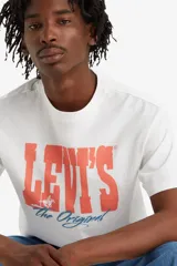 Remera blanca de algodón con cuello redondo y estampado frontal con el logo de Levi's en color coral y la frase "The Original" en celeste.