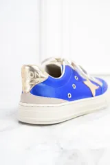 Zapatillas de cuero metalizado color azul con estrella dorada en el lateral, cordones blancos y detalles en color crema.
