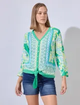 Blusa estampada con escote en V, abertura central con botones y terminación anudada. Largo de manga regulable con presilla y botón.