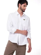Camisa de manga larga blanca de popelina de algodón, de corte clásico con cuello camisero, cierre frontal con botones y bolsillo en el pecho con etiqueta de la marca.