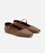 Zapatilla plana de cuero marrón estilo Mary Jane, con puntera cuadrada y tira fina con hebilla metálica dorada sobre el empeine.
