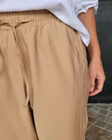 Pantalón color beige de corte recto con cintura elastizada y cordón ajustable.