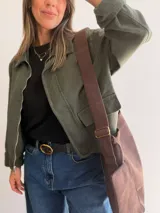 Chaqueta de corte recto color camel, con cierre frontal de cremallera, cuello camisero y puños en tejido de pana a tono. Presenta bolsillos frontales tipo parche y diseño estructurado.